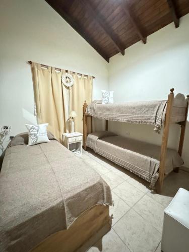 a bedroom with two beds and a window at Quinta El Arrayan in Tandil