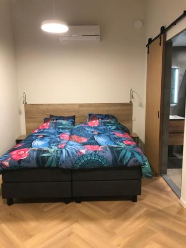 a bedroom with a bed with a colorful comforter at B&B An de N35 in Zwolle