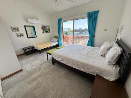 ein Schlafzimmer mit einem Bett und einem großen Fenster in der Unterkunft Sunset Cove in Jolly Harbour