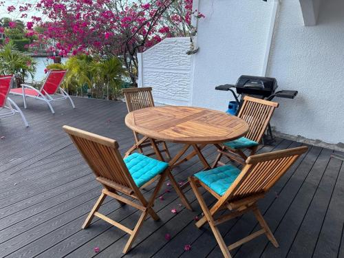 ein Holztisch und Stühle auf einer Terrasse in der Unterkunft Sunset Cove in Jolly Harbour