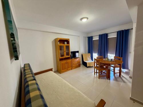 a living room with a table and a dining room at Caravela B in Armação de Pêra