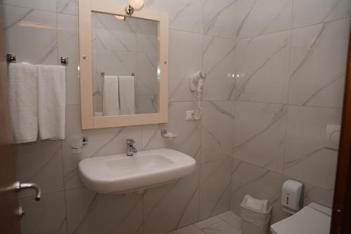 a white bathroom with a sink and a mirror at Resort Nord Park in Fushë-Krujë