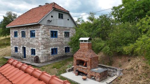 an old stone house with a brick oven in the yard at Etno kuća Krvavac in Pljevlja