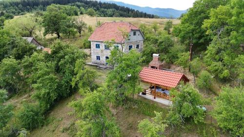 an old house with a red roof on a hill at Etno kuća Krvavac in Pljevlja