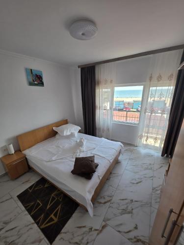a bedroom with a large bed with a large window at Vila Madi in Vama Veche
