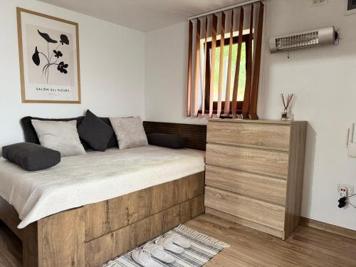 a bedroom with a bed and a wooden dresser at La Căsuță Rudeni in Rudeni
