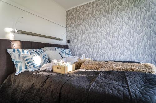 a bedroom with a bed with a gray wall at Horizont Hillside Mályinka in Mályinka