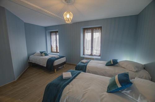 a blue room with two beds and a window at Le gîte du château 2 in Crespy-le-Neuf