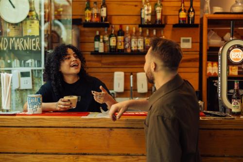 a woman talking to a man at a bar at Lisbon Destination in Lisbon