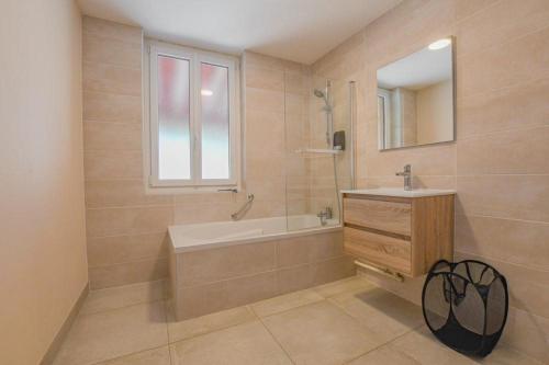 a bathroom with a tub and a sink and a mirror at Le gîte du château 1 in Crespy-le-Neuf