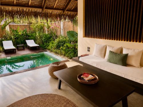 a living room with a couch and a table and a pool at Nayma Villas in General Luna