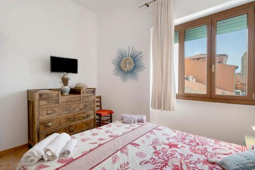 a bedroom with a bed with a dresser and a window at Casa Silvia trilo calagavetta in La Maddalena