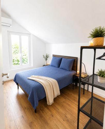 a bedroom with a blue bed and a window at Le temps d'une pause -3- in Cepoy