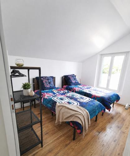 a bedroom with two beds and a mirror at Le temps d'une pause -3- in Cepoy