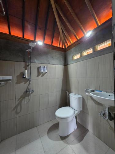 a bathroom with a toilet and a sink at Aura V Bungalow in Praya