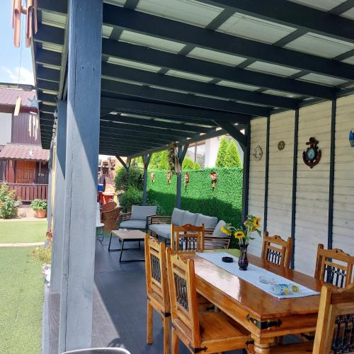 a patio with a wooden table and chairs at Casa Rustica in Mamaia Sat/Năvodari