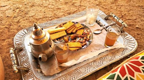 a tray with a plate of food on a table at Caravane du bonheur in Mhamid