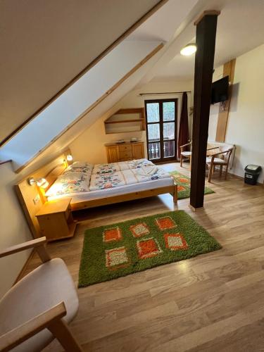a attic bedroom with a bed and a table at Penzion Stárek in Terchová