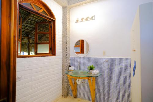 a bathroom with a table with a mirror and a sink at Las Golondrinas KM59 in Taquillo