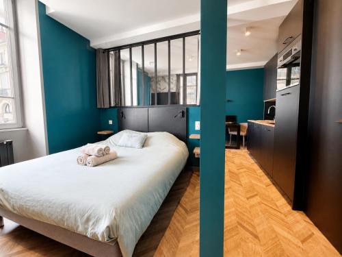 a bedroom with blue walls and a bed with two towels at La Loge AL'AIX in Aix-les-Bains