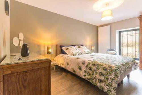 a bedroom with a bed and a dresser and a window at Le Moulin de Commagny in Moulins-Engilbert