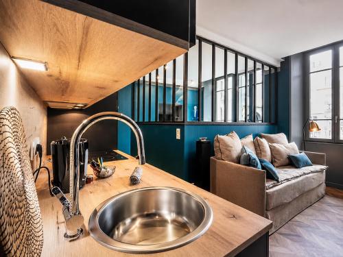 a kitchen with a sink and a couch at La Loge AL'AIX in Aix-les-Bains