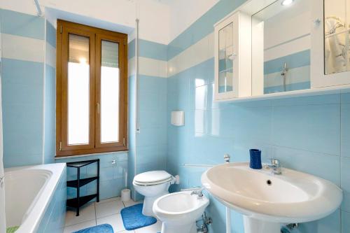 a blue bathroom with a sink and a toilet and a tub at Casa Silvia trilo calagavetta in La Maddalena