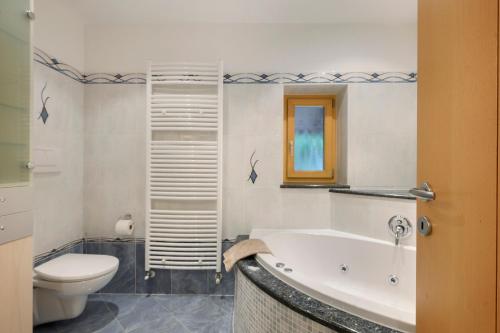 a bathroom with a white tub and a toilet at Altebnerhof Leifers in Laives