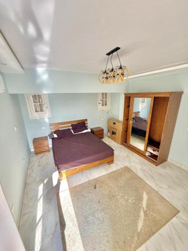 a bedroom with a bed and a mirror at شاليه بقرية الفيروز in Qaryat Shurūq