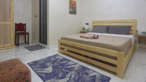 a bedroom with a large bed and a chair at Rooftop Hostel Dakhla in Dakhla