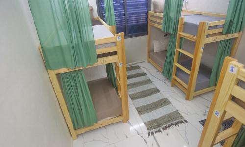 a room with two bunk beds and a rug at Rooftop Hostel Dakhla in Dakhla