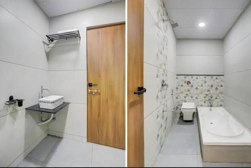 a bathroom with a toilet and a wooden door at Hotel the Infinity in Rajkot