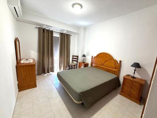 a bedroom with a bed and a dresser and a table at Edificio Nau in Armação de Pêra