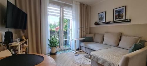 a living room with a couch and a large window at Silverka Studio in Tarnowskie Góry