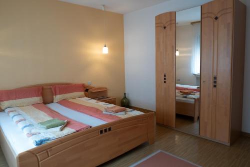 a bedroom with a large bed and a mirror at Ferienwohnung Weißburgunder in Klüsserath
