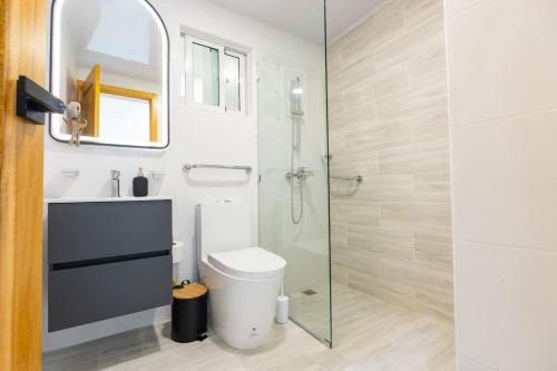 a bathroom with a toilet and a glass shower at Modern 3BR! 9fl, King Bed! Sti!, in Santiago de los Caballeros