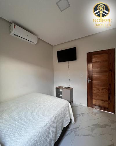 a bedroom with a bed and a flat screen tv at Casa completa com 2 quartos no Bairro Alvorada in Santarém
