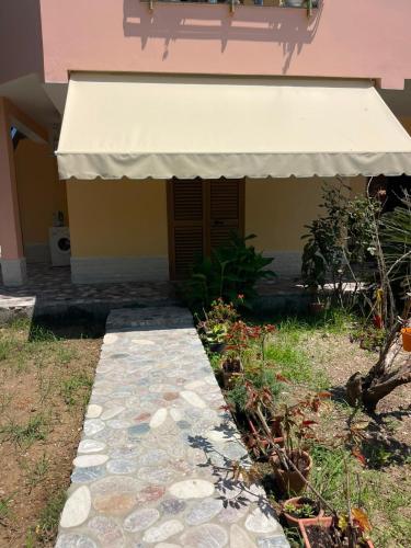a building with a white awning and a walkway at Besart Room in Orikum