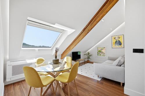 a white living room with a glass table and yellow chairs at Pardavila 57 Slow Hotel in Marín