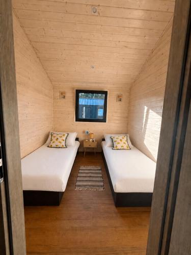 two beds in a small room with a window at Łeba Luxury House in Łeba