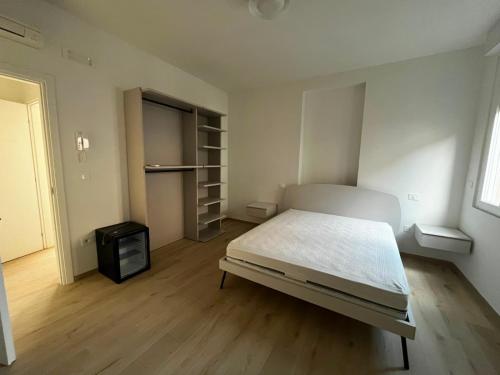 a white bedroom with a bed and a television at Bigò Apartments in Termoli
