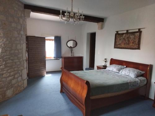 a bedroom with a bed and a stone wall at gite La Tour Au Comté in Charency