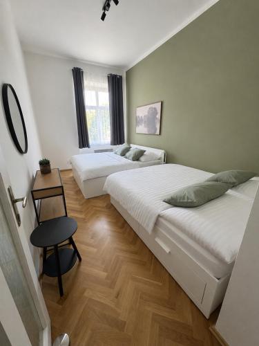 a bedroom with two beds and a stool in it at City Apartment 920 in Pardubice
