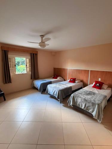 a room with three beds and a ceiling at Hotel Canaã Express in Jarinu