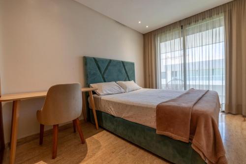 a bedroom with a bed with a desk and a chair at Comfort and luxury with pool in Tamaris