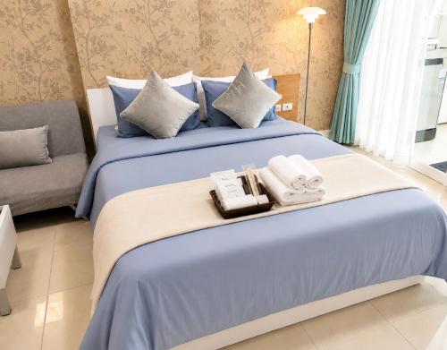 a hotel room with a bed with two complimentary towels at Modern 12th Floor Condo Walk to Phuket Old Town with Pool & Gym in Phuket
