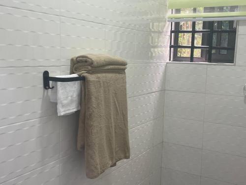 a towel is hanging on a rack in a bathroom at Da Palm boutique resort in Aburi