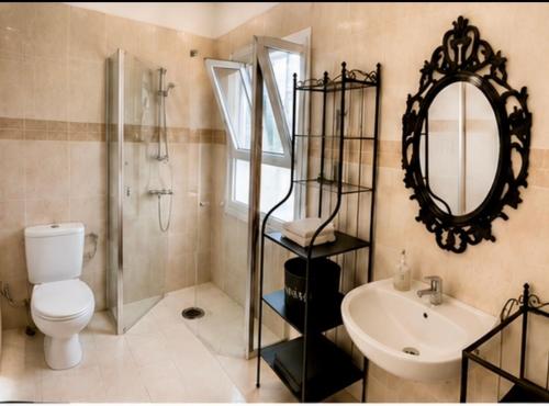 a bathroom with a toilet and a sink and a mirror at Kyel location in Ashdod