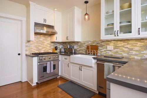 a kitchen with white cabinets and a sink and a stove at Playa One Bedroom (251) in Carpinteria