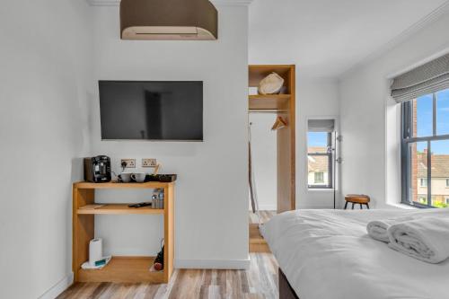 a bedroom with a bed and a tv on the wall at Larkey View A Tranquil Space For Two - Pass the Keys in Canterbury